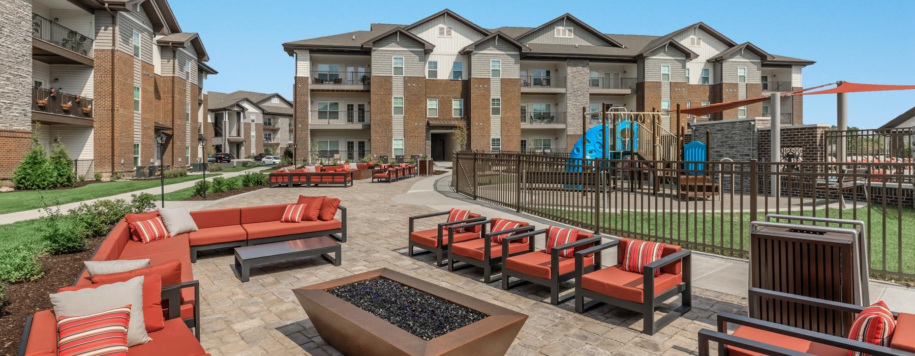 a patio with tables and chairs and a fire pit